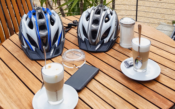 Latte-Macchiato und Helme auf Tisch